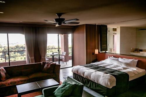 ein Hotelzimmer mit einem Bett und einem Sofa in der Unterkunft 浜名湖オーベルジュ　キャトルセゾン in Ōsaki
