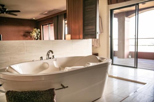 a white bath tub in a bathroom with a window at 浜名湖オーベルジュ　キャトルセゾン in Ōsaki