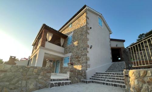 uma casa com escadas e uma parede de pedra em Villa Copun with heated pool em Rab