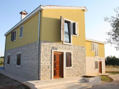 ein kleines gelbes und graues Haus mit einer roten Tür in der Unterkunft Splendid Holiday Home in Novigrad near sea in Novigrad Istria