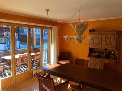 a dining room with a wooden table and a balcony at Plattis 4 in Klosters