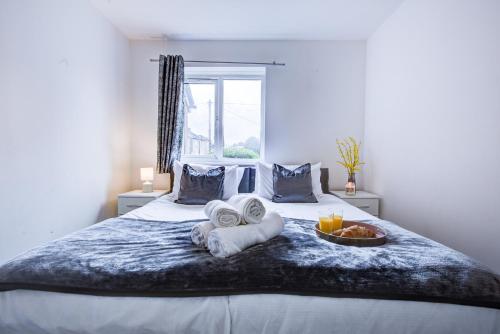 a bed with towels and a bowl of fruit on it at Inviting Urban Apartment in Croydon in Croydon
