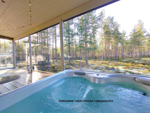 a hot tub in a house with a large window at Villa Tuomipakka in Kalajoki
