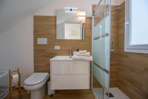 uma casa de banho com um WC, um lavatório e um espelho. em Charming House Sveleo - SiciliaVacanza em Marzamemi