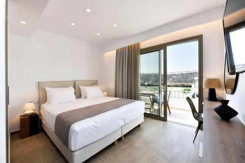 a bedroom with a large bed and a balcony at Anais Milos Suites in Adamas