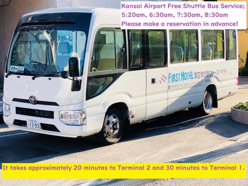 Kansai Airport First Hotel في إيزوميسانو: حافلة بيضاء متوقفة على جانب شارع