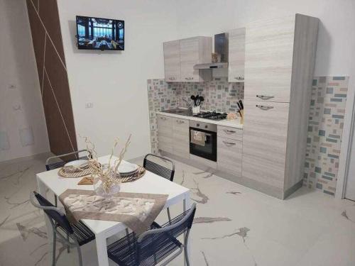 cocina con mesa y sillas y cocina con fogones en NewLife 815 Holiday Home White, en Mercato San Severino