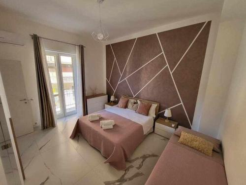 1 dormitorio con 1 cama grande y pared grande en NewLife 815 Holiday Home White, en Mercato San Severino