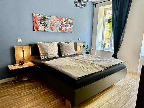 Bett in einem Schlafzimmer mit blauer Wand in der Unterkunft Wohlfühloase im hippen Leipziger Osten in Leipzig