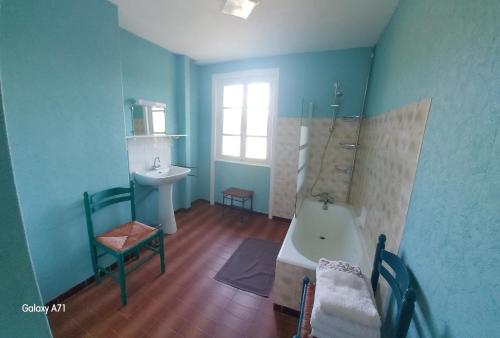 La salle de bains bleue est pourvue d'une baignoire et d'un lavabo. dans l'établissement Vacances à la campagne, 