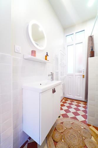 une salle de bain blanche avec un lavabo et un miroir dans l'établissement Villa Adèle, Escapade Belle-Époque - Appt 01, à Mers-les-Bains