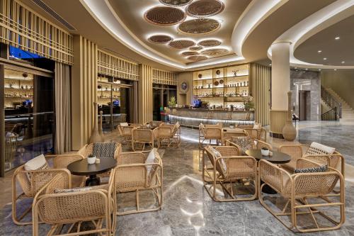 un restaurante con mesas y sillas y un bar en Titanic Luxury Collection Bodrum en Guvercinlik