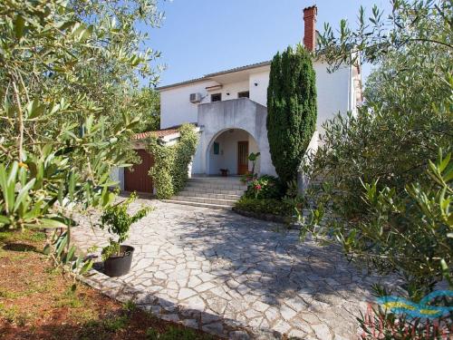 uma casa com um caminho que leva ao jardim da frente em Nice apartment with terrace and grill for use em Malinska