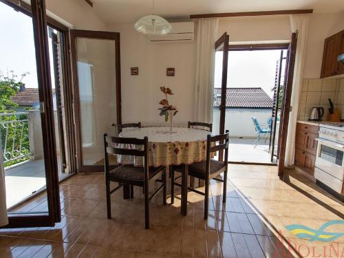 - une salle à manger avec une table et des chaises dans l'établissement Nice apartment with terrace and grill for use, à Malinska