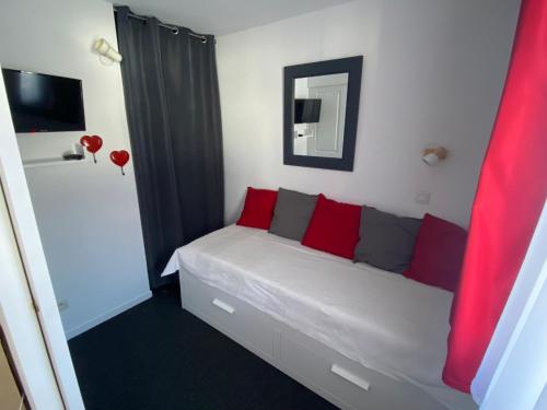 a bedroom with a bed with red and grey pillows at Appartement 4 personnes in Risoul