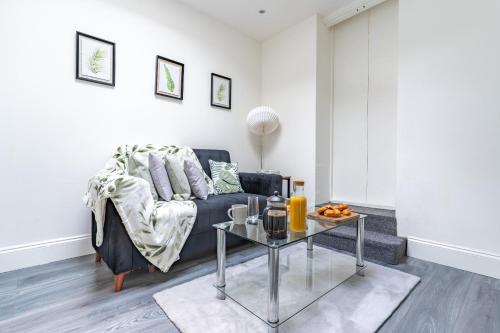 uma sala de estar com um sofá e uma mesa em Prime Location - Cosy Apartment near Emirates Stadium em Londres