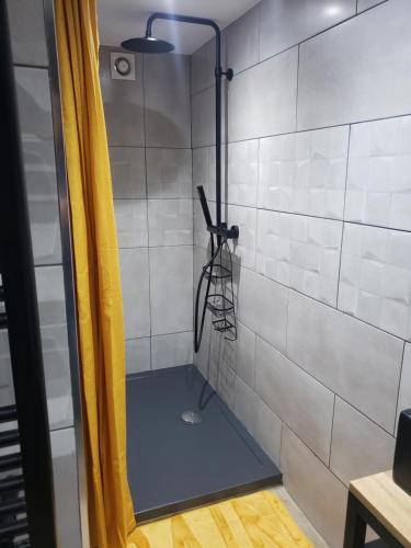une douche dans une salle de bain avec un rideau jaune dans l'établissement COSY, à Coubron