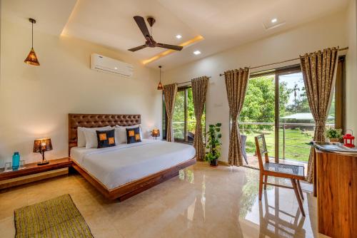 a bedroom with a bed and a large window at SaffronStays Lakeview Nivara - Farm Stay Villa with Private Pool near Pune in Pune