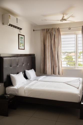 a bedroom with a large bed and a window at Catalyst Suites, Rajaji Nagar in Bangalore