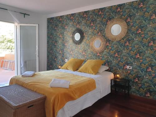 um quarto com uma cama grande e papel de parede floral em Villa Oasis em Chío