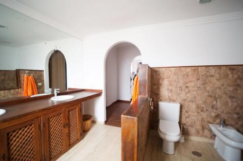 uma casa de banho com um lavatório e um WC em Villa Oasis em Chío