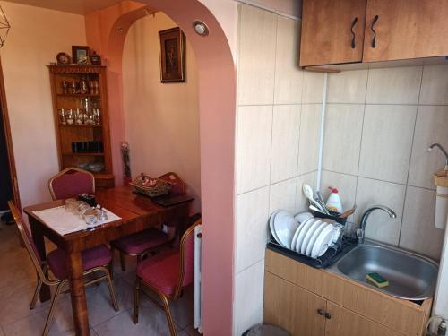 cocina con fregadero, mesa y mesa en Grati’s house, en Constanţa
