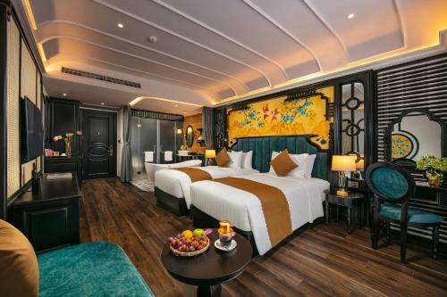 a hotel room with a large bed and a living room at Grand Sunrise Palace Hoi An- A Luxury Indochine Hotel & Spa in Hoi An