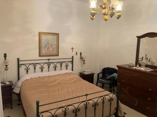 1 dormitorio con cama, tocador y espejo en Casa vacanza IL MELOGRANO Giuggianello (Lecce), en Giuggianello