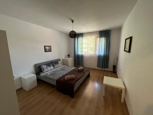 a small bedroom with a bed and a table at АПАРТАМЕНТ МАЯ с две спални in Kazanlŭk