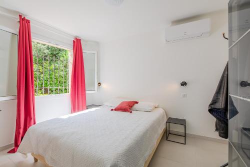 une chambre avec un lit avec des rideaux rouges et une fenêtre dans l'établissement Villa Elda - Charmante maison vue mer - Plage à pied, à Saint-Peïre-sur-Mer