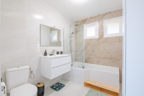 une salle de bain blanche avec un lavabo et une douche dans l'établissement Villa Elda - Charmante maison vue mer - Plage à pied, à Saint-Peïre-sur-Mer
