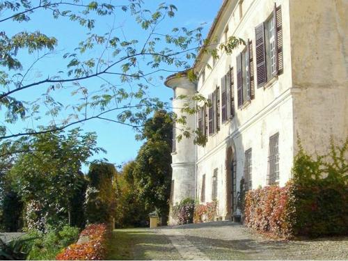 un gran edificio blanco con ventanas laterales en Luxurious Apartment in Rocca Grimalda with Garden, en Rocca Grimalda