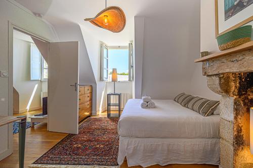 une chambre avec un lit et une cheminée dans l'établissement Au coeur des Remparts - Bel appt coeur de Vannes, à Vannes