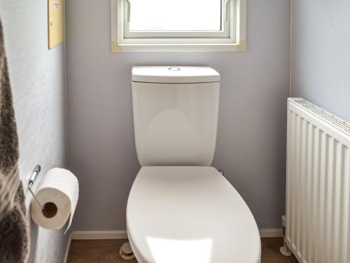 a white toilet in a bathroom with a window at Summer Willow Lodge in Tattershall