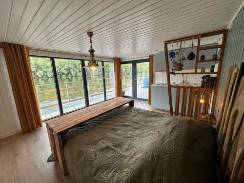 ein Schlafzimmer mit einem großen Bett in einem Zimmer mit Fenstern in der Unterkunft Rêve sur l’eau in Moisson
