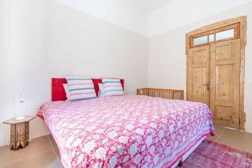 a bedroom with a bed with a red and white comforter at Brand New Gem In Talbiyeh in Jerusalem