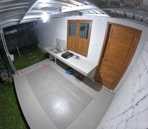einen Blick über ein Zimmer mit einem Schreibtisch und einer Tür in der Unterkunft Bovalia Homestay Jogja in Seturan