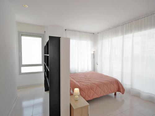 a white bedroom with a bed and a window at Casa Angel in L'Escala