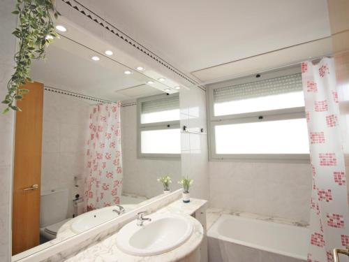 a bathroom with a sink and a tub and a mirror at Casa Angel in L'Escala