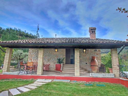een groot stenen huis met een grote patio bij Large holiday home in Cagli with pool in Acqualagna