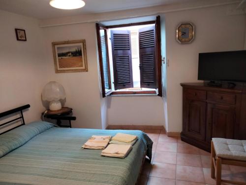 - une chambre avec un lit, une télévision et une fenêtre dans l'établissement La casa della Nonna, à Codiponte