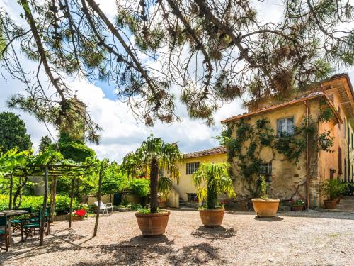 einen Innenhof mit Topfpflanzen und ein Gebäude in der Unterkunft Cosy Farmhouse in Bacchereto with Swimming Pool in Carmignano