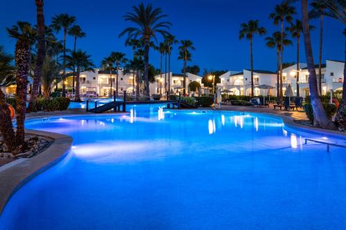 a large swimming pool at night with palm trees at Garden Holiday Village - Adults Only in Playa de Muro