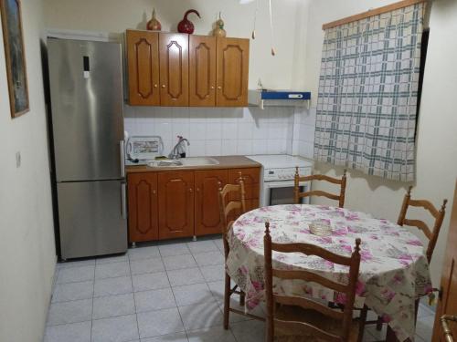 una pequeña cocina con mesa y nevera en Studios Θάλεια en Néos Pírgos