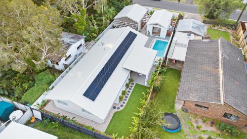 uma vista aérea de uma casa com painéis solares no telhado em Brand new coastal oasis - family & pet friendly. em Coolum Beach