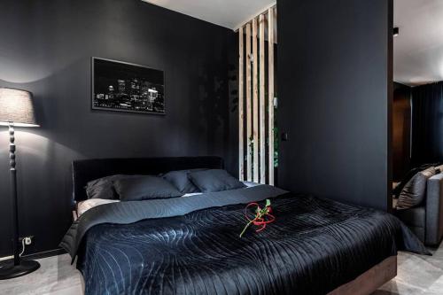 a black bedroom with a bed with scissors on it at Krakowskie30 Loft1 deptak in Lublin
