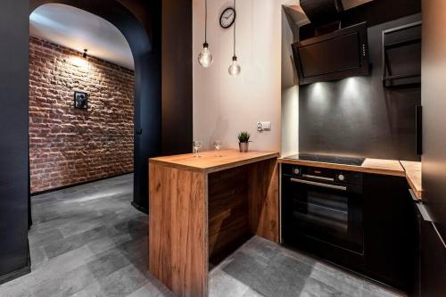 cocina con encimera de madera y pared de ladrillo en Krakowskie30 Loft1 deptak, en Lublin