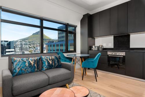 sala de estar con sofá y mesa en The Tokyo Aparthotel by Totalstay en Ciudad del Cabo