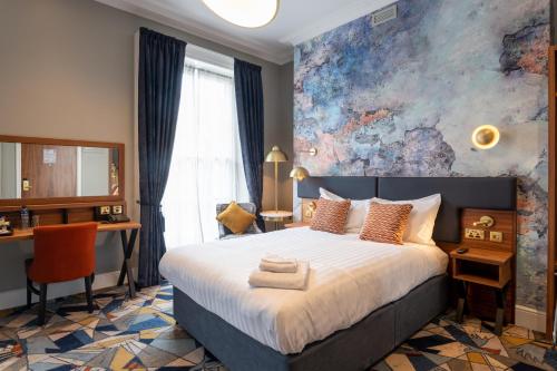 1 dormitorio con 1 cama grande y escritorio en Keavan's Port Hotel , Dublin, en Dublín