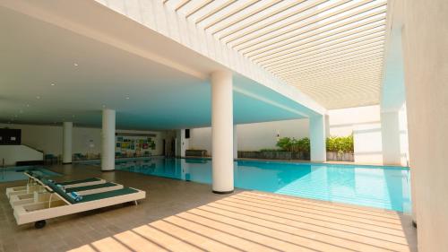 a large swimming pool with a large ceiling at Signature Club Resort in Devanahalli-Bangalore